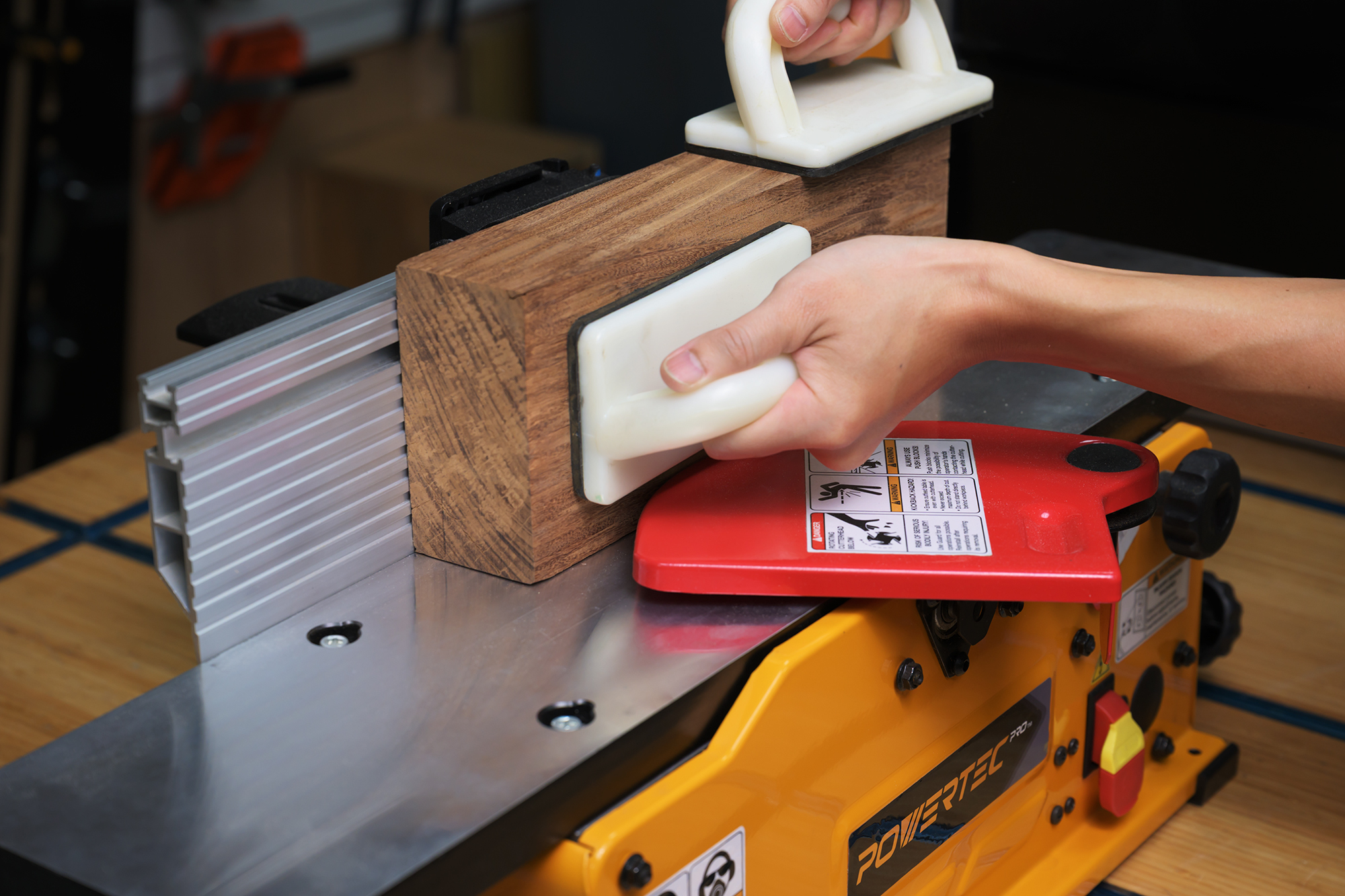 POWERTEC BJ603 in use — board being jointed on the table, focus on the fence and cutting surface.